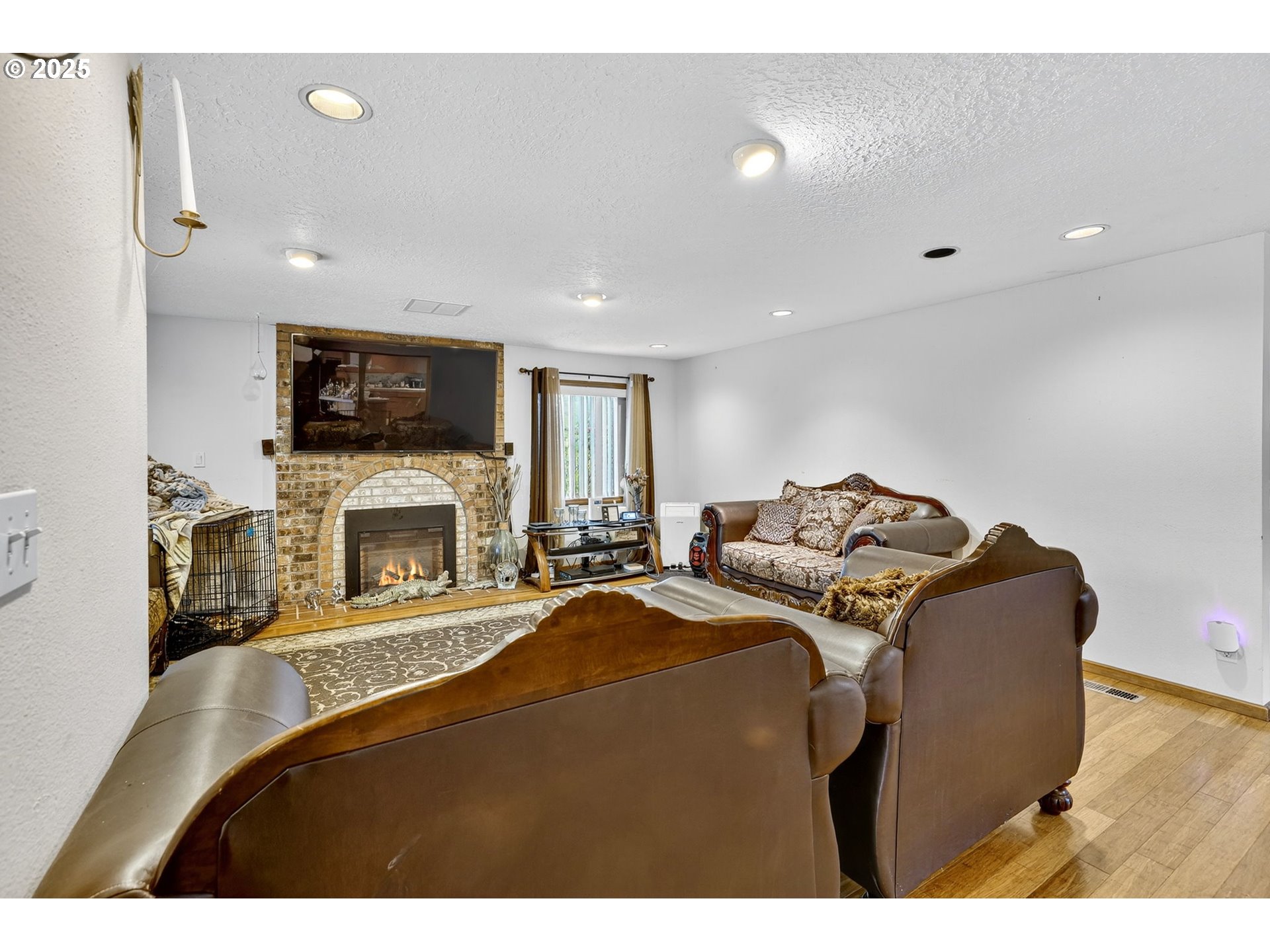 8739 Southeast Knapp Street Portland, OR 97266 - Photo 7 of 23 a living room with furniture a fireplace and a flat screen tv