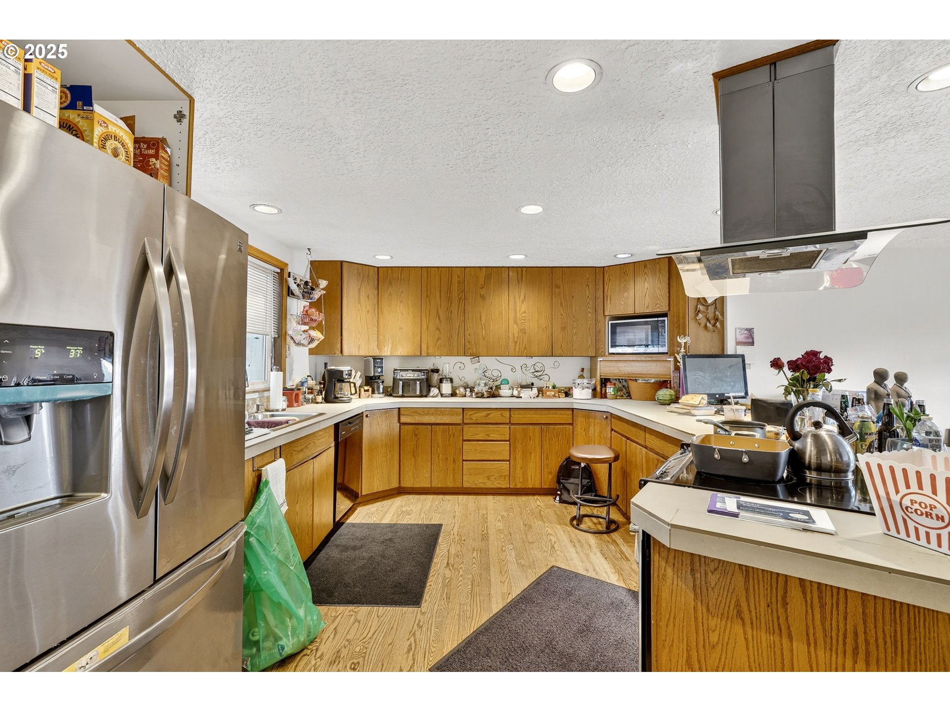 8739 Southeast Knapp Street Portland, OR 97266 - Photo 9 of 23 a kitchen with a sink a stove top oven a refrigerator and white cabinets