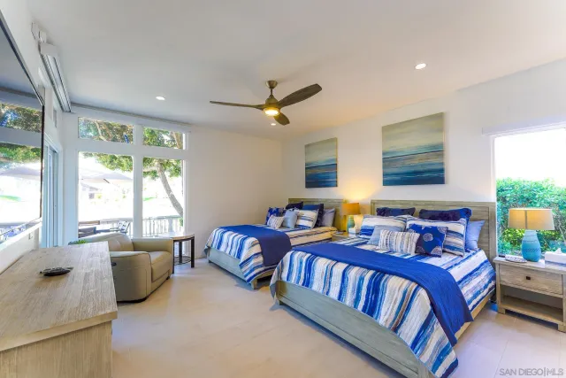 a bedroom with two beds and a large window