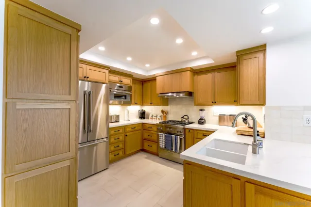 a kitchen with a sink a refrigerator and cabinets