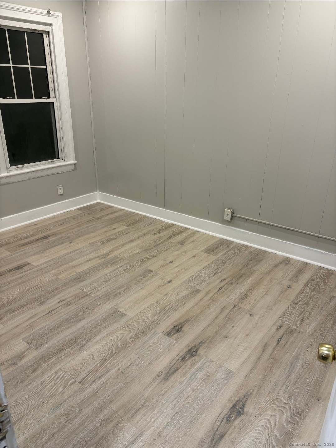190 Howard Avenue, Unit 1 Ansonia, CT 06401 - Photo 4 of 7 a view of an empty room with wooden floor and a window