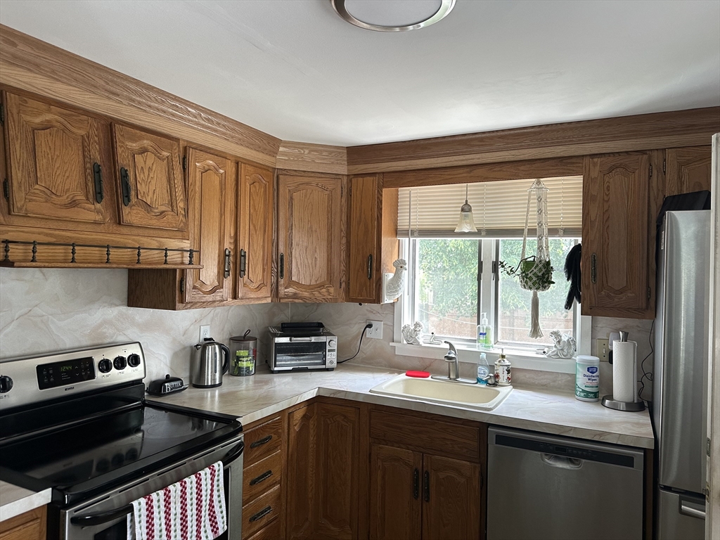 110 Holyoke Street Lynn, MA 01905 - Photo 6 of 13 a kitchen with stainless steel appliances a sink cabinets and a window
