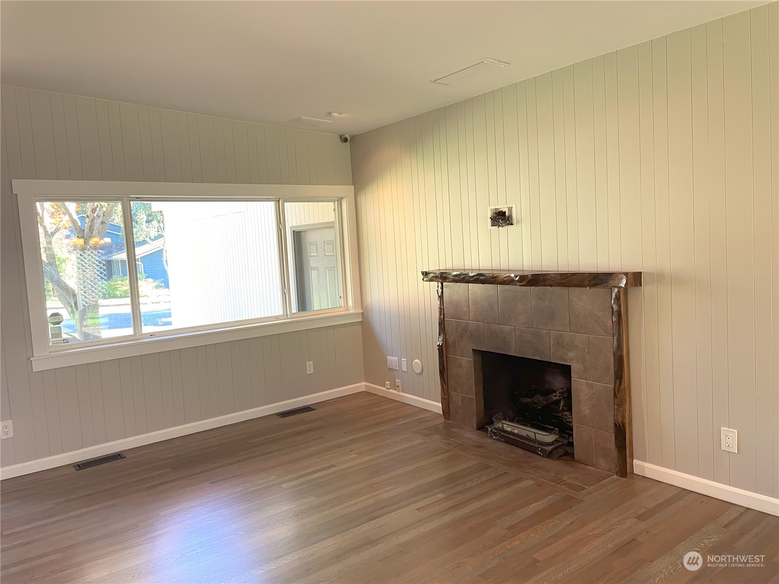 20043 96th Avenue Northeast Bothell, WA 98011 - Photo 2 of 13 an empty room with wooden floor fireplace and windows