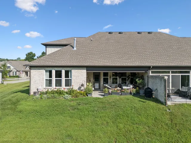 a backyard of a house with yard table and chairs