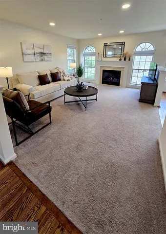 a living room with furniture fireplace and a large window