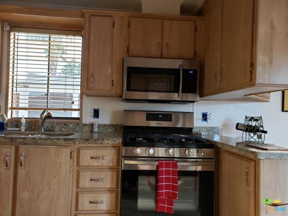69801 Ramon Road, Unit 192 Cathedral City, CA 92234 - Photo 12 of 14 a kitchen with stainless steel appliances granite countertop a stove and a microwave