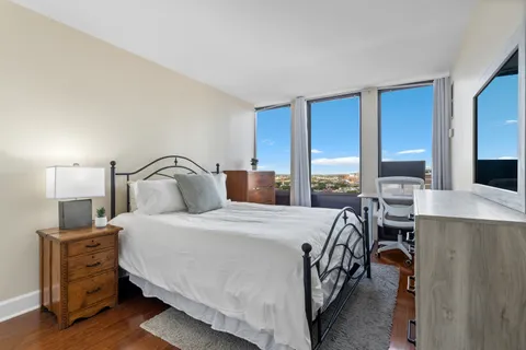 a bedroom with a bed and large windows