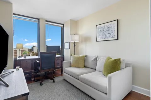 a living room with furniture and a air conditioner vent
