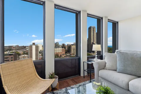 a living room with furniture a city view and a large window
