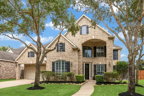 a front view of a house with a yard and trees
