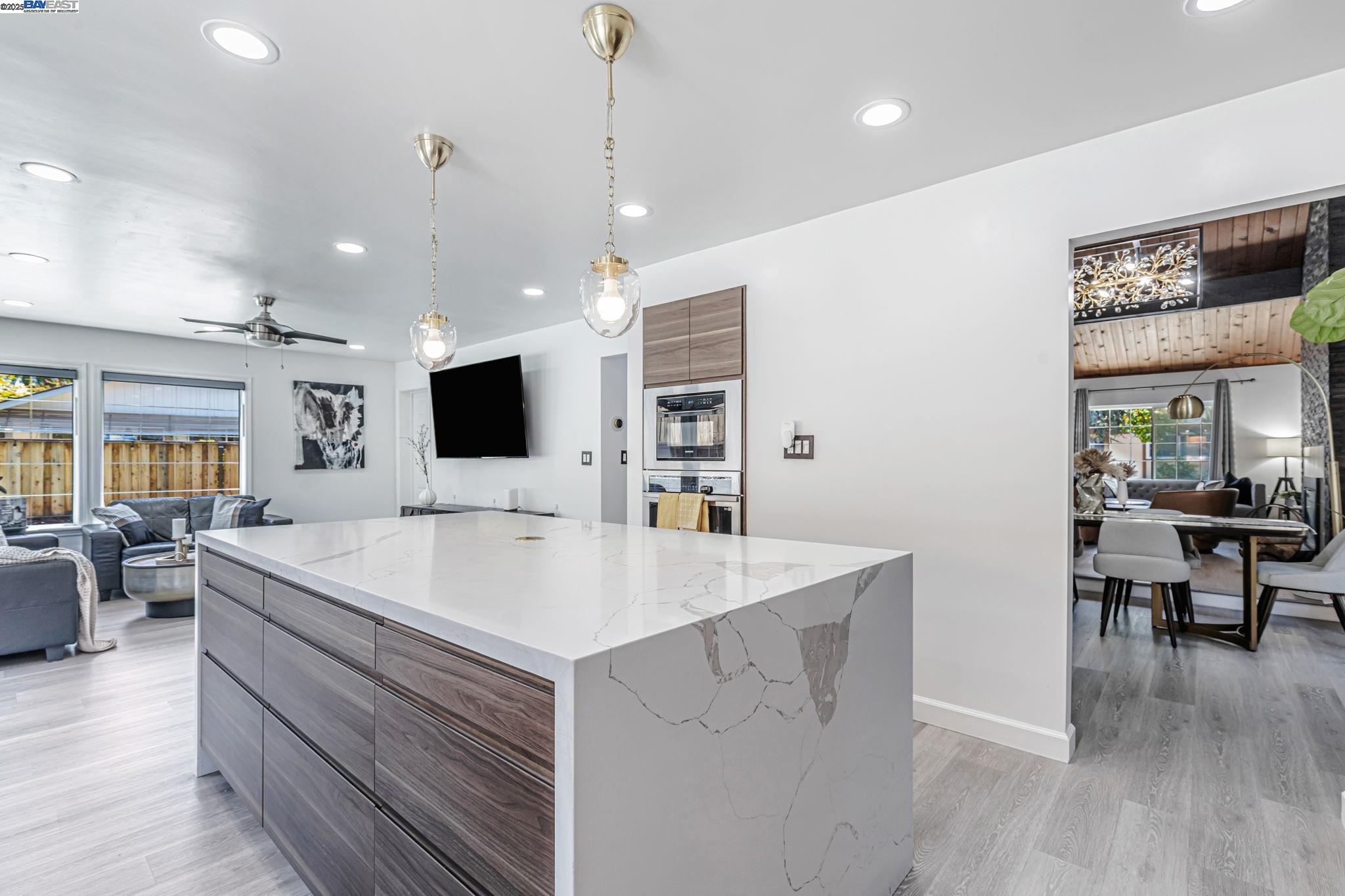 1835 Camino Estrada Concord, CA 94521 - Photo 6 of 27 a large white kitchen with a large island oven a stove a couch a dining table and chairs