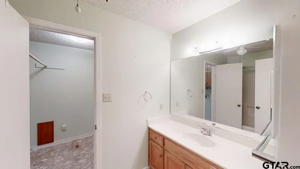 a bathroom with a sink vanity granite and shower