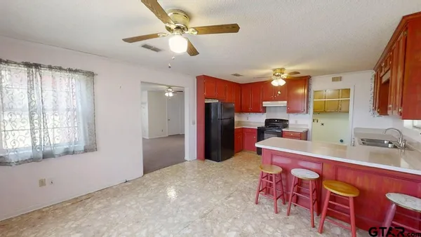 a kitchen with a refrigerator a sink dishwasher with a dining table and chairs