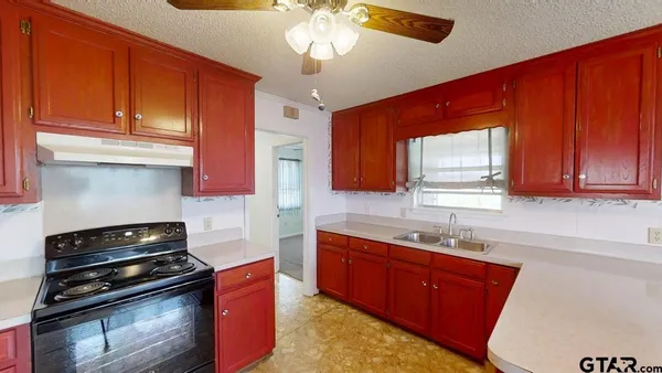 a kitchen with stainless steel appliances granite countertop a sink stove and cabinets