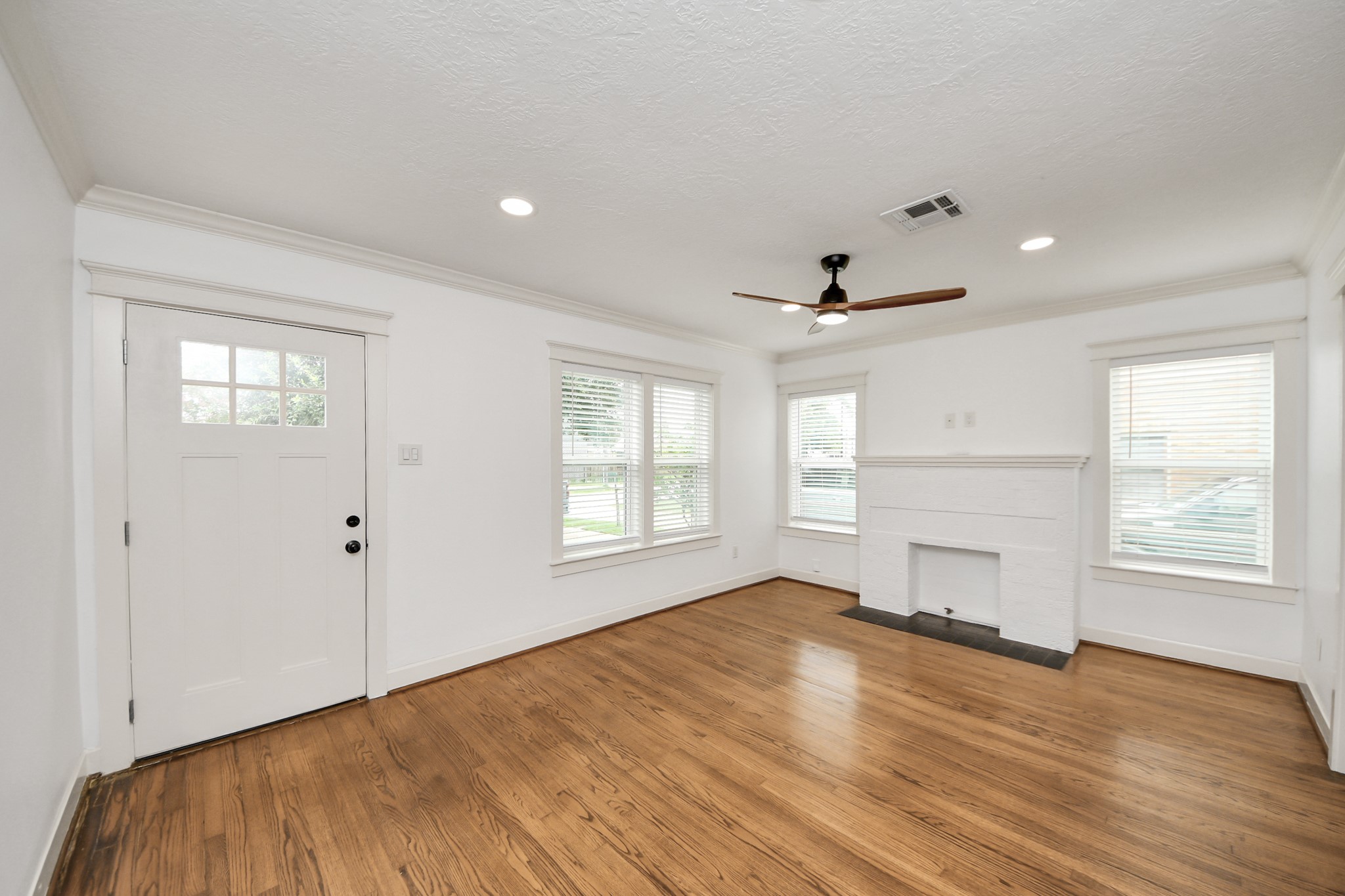 609 Reid Street Houston, TX 77022 - Photo 12 of 48 an empty room with wooden floor and windows