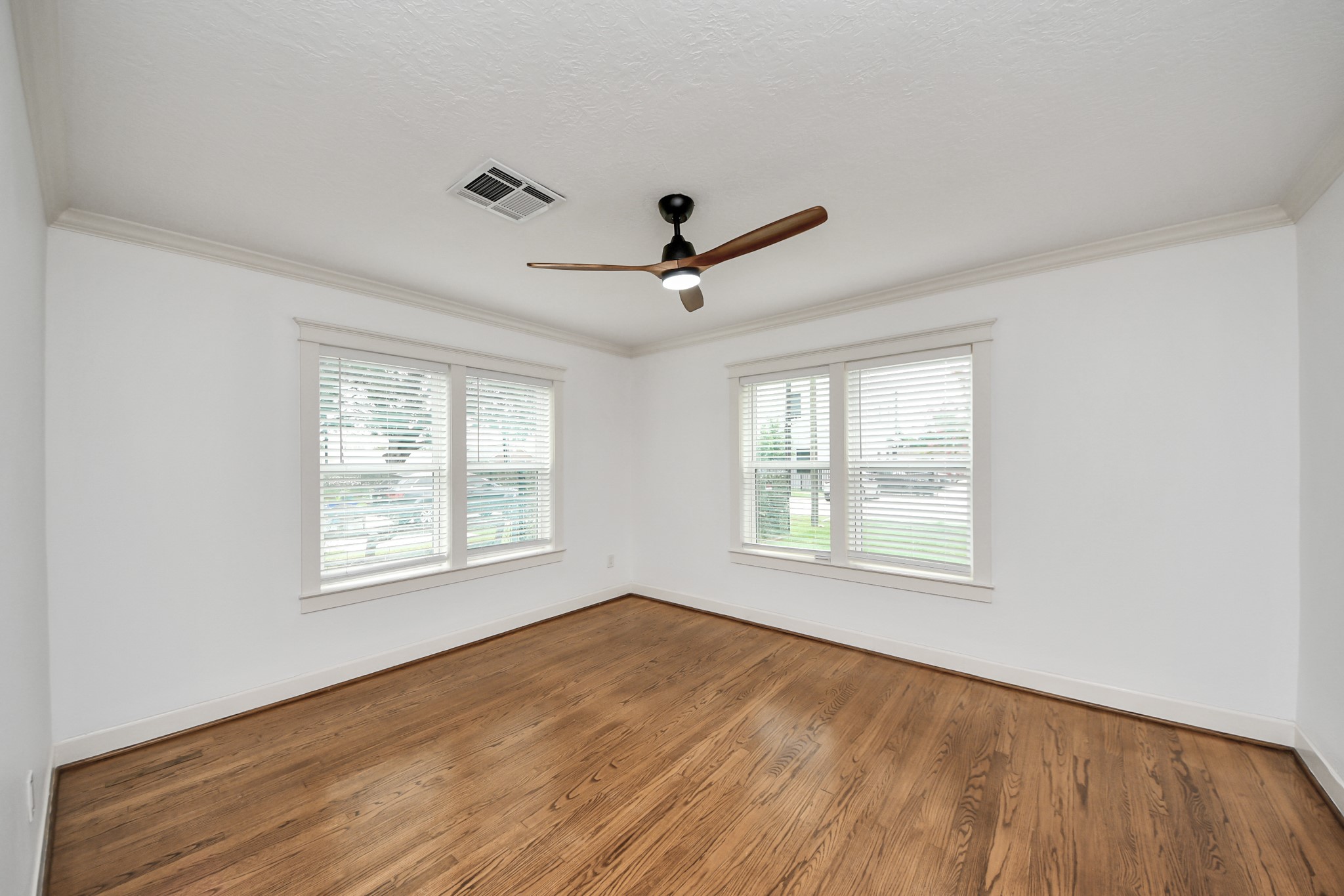 609 Reid Street Houston, TX 77022 - Photo 29 of 48 a view of an empty room with a window and wooden floor