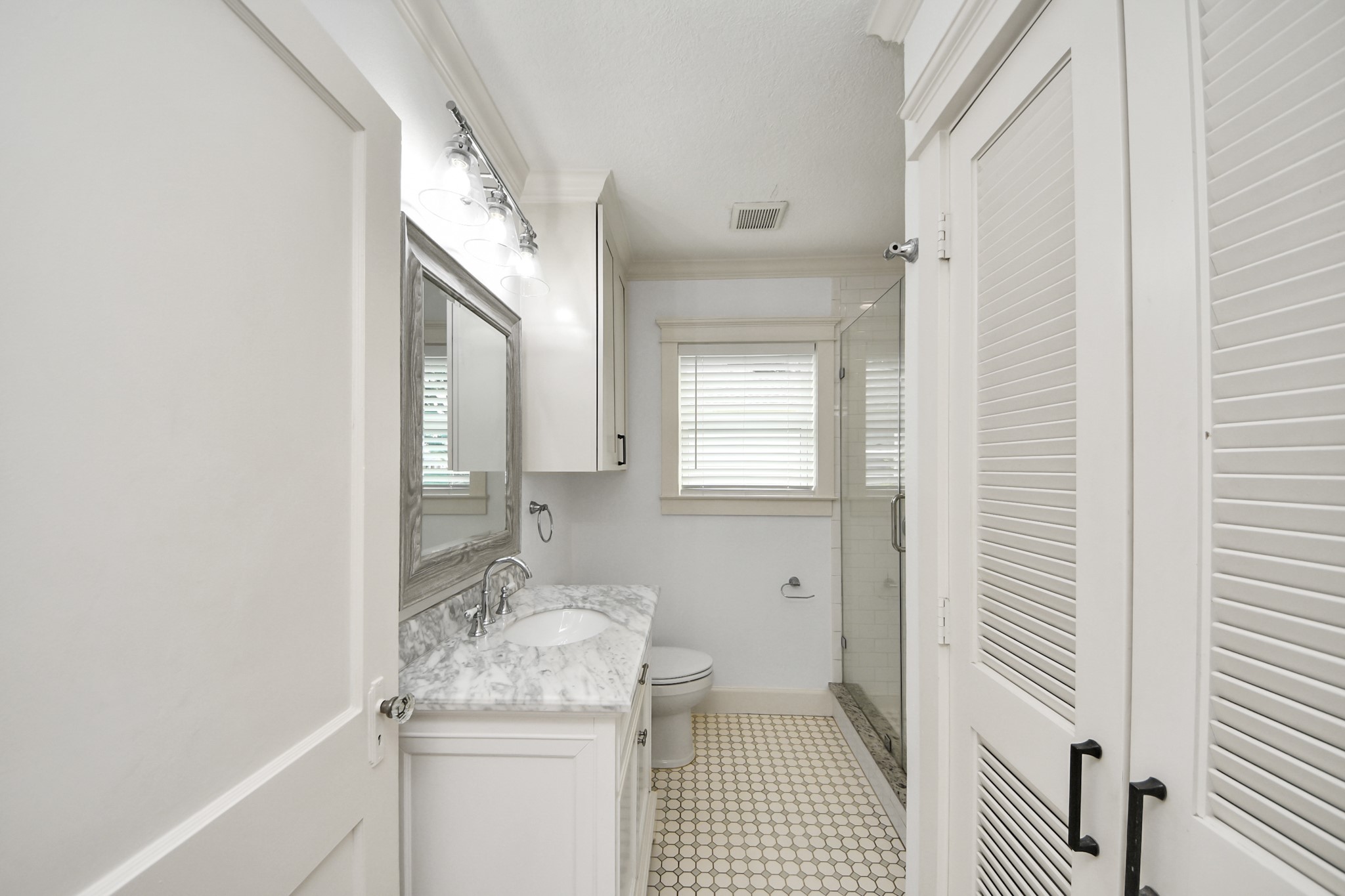 609 Reid Street Houston, TX 77022 - Photo 32 of 48 a bathroom with a granite countertop sink a toilet and a mirror