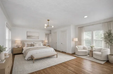 a spacious bedroom with a bed and wooden floor