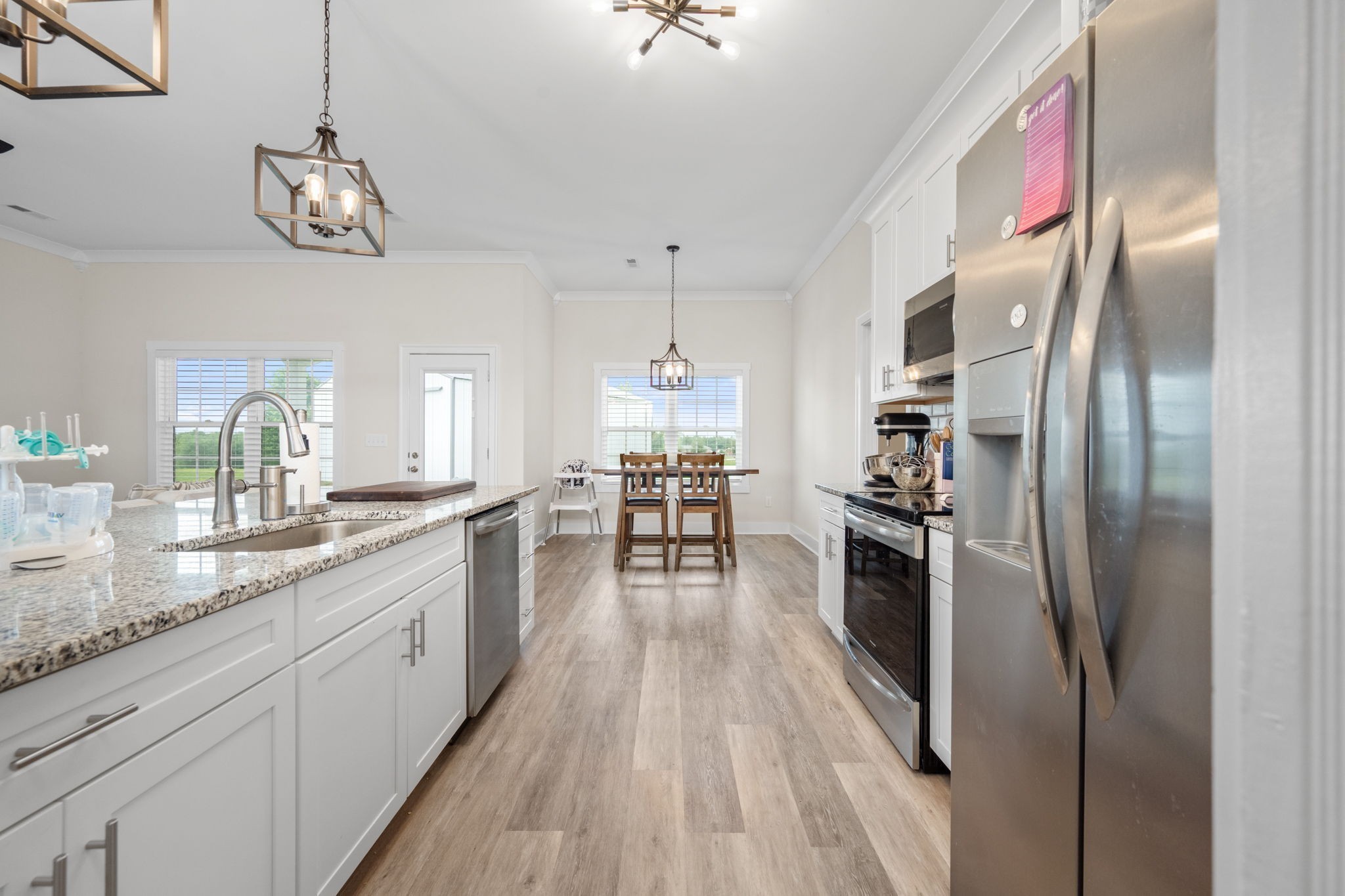 65 Joe Blanton Road Woodbury, TN 37190 - Photo 22 of 61 a kitchen with stainless steel appliances granite countertop a refrigerator a sink dishwasher a oven and a dining table with wooden floor