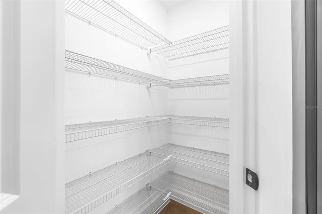 a view of walk in closet with empty racks