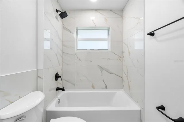 a bathroom with a bathtub a toilet and a shower