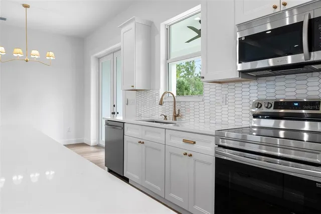 a kitchen with stainless steel appliances a stove microwave and sink