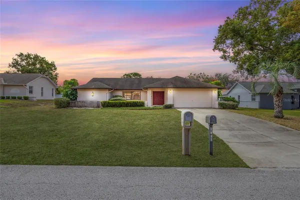 a front view of a house with a garden and yard