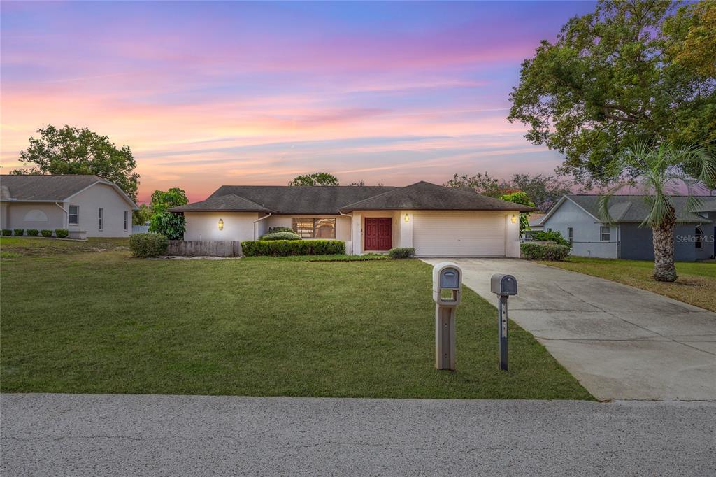 a front view of a house with a garden and yard