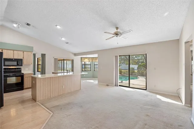 a view of an empty room with a window and cabinet
