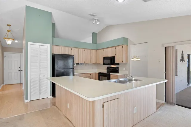 a kitchen with a sink a counter top space stainless steel appliances and cabinets