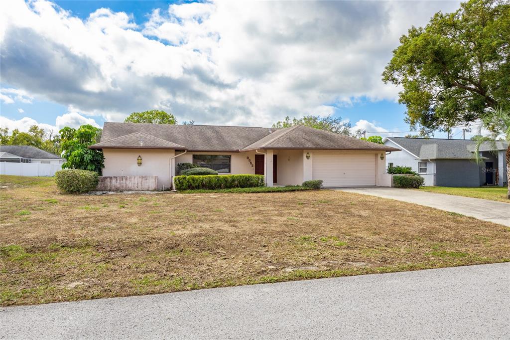 8352 Natoma Street Spring Hill, FL 34606 - Photo 4 of 48 a front view of a house with a garden