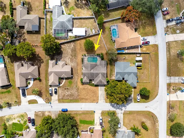an aerial view of a house with a yard and trees