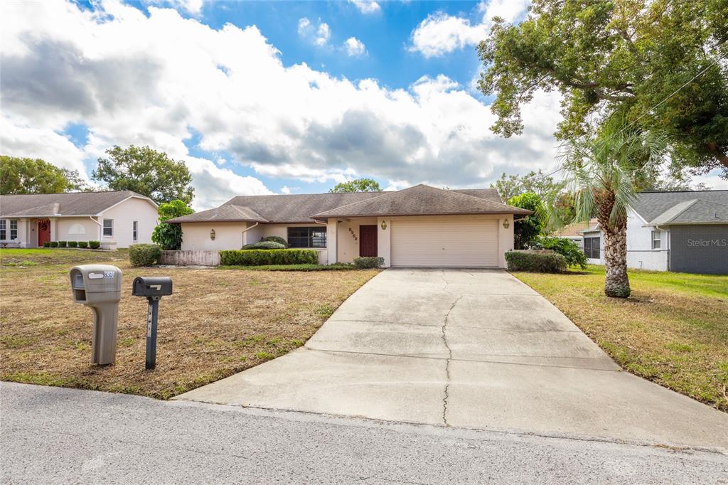 8352 Natoma Street Spring Hill, FL 34606 - Photo 5 of 48 a front view of a house with a yard and garage