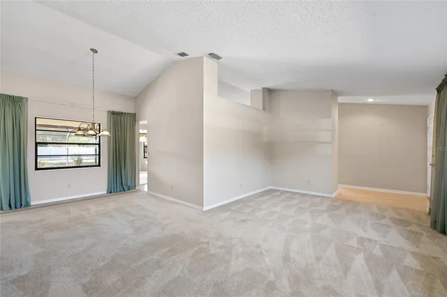 an empty room with windows and cabinet