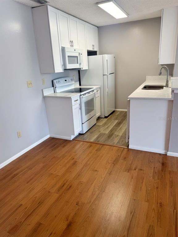 711 Sugar Bay Way, Unit 313 Lake Mary, FL 32746 - Photo 19 of 25 a kitchen with stainless steel appliances a sink dishwasher a refrigerator a stove top oven a counter space and cabinets