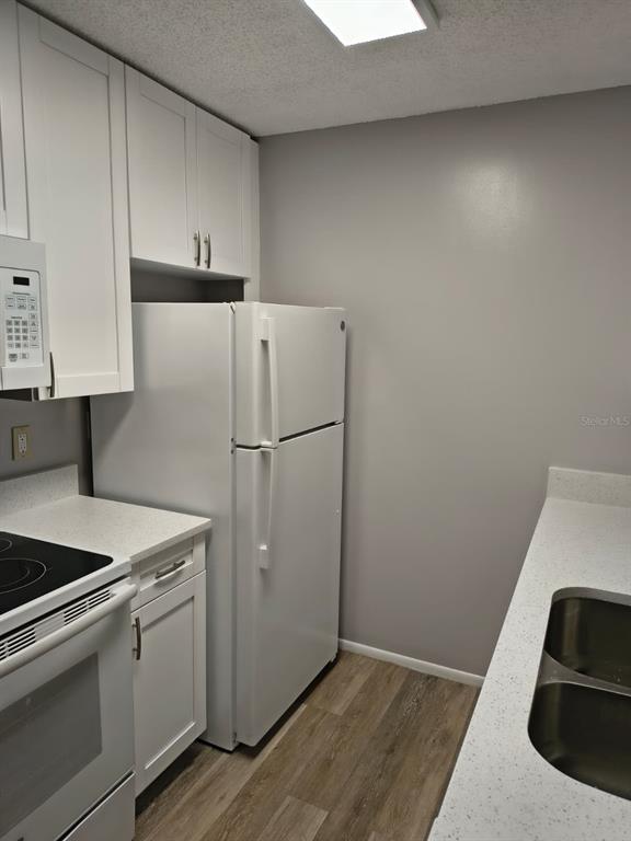 711 Sugar Bay Way, Unit 313 Lake Mary, FL 32746 - Photo 5 of 25 a kitchen with a refrigerator and a stove top oven