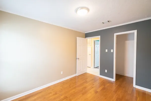 a view of empty room with window and hardwood