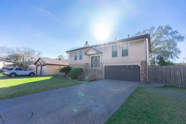 a front view of house with yard and trees in the background