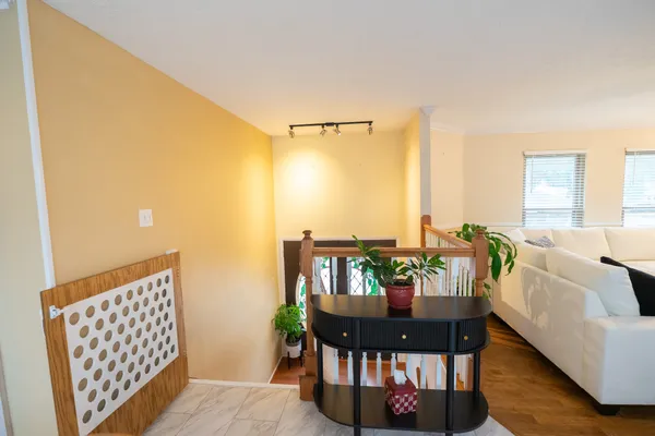a view of a room with wooden floor and a ceiling fan