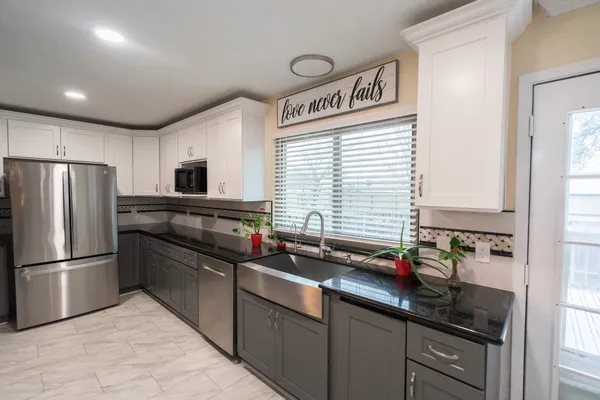a kitchen with stainless steel appliances a sink stove and refrigerator