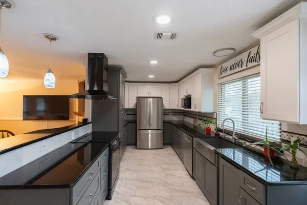 a kitchen with stainless steel appliances a refrigerator and a stove top oven