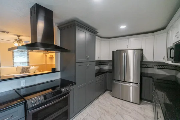 a kitchen with kitchen island granite countertop a sink cabinets and window