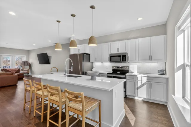 a kitchen with stainless steel appliances kitchen island granite countertop a sink and microwave