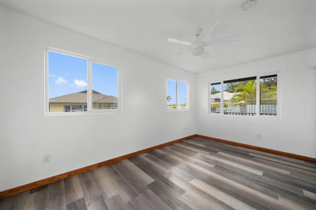 a view of empty room with window and ceiling fan