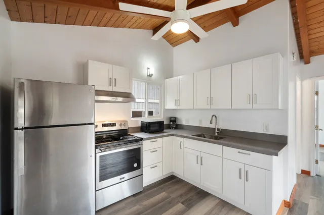 a kitchen with a refrigerator a sink and cabinets