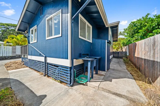 a view of house with wooden stairs and a small yard