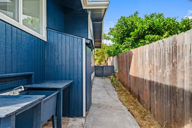 a view of a backyard with wooden fence and plants