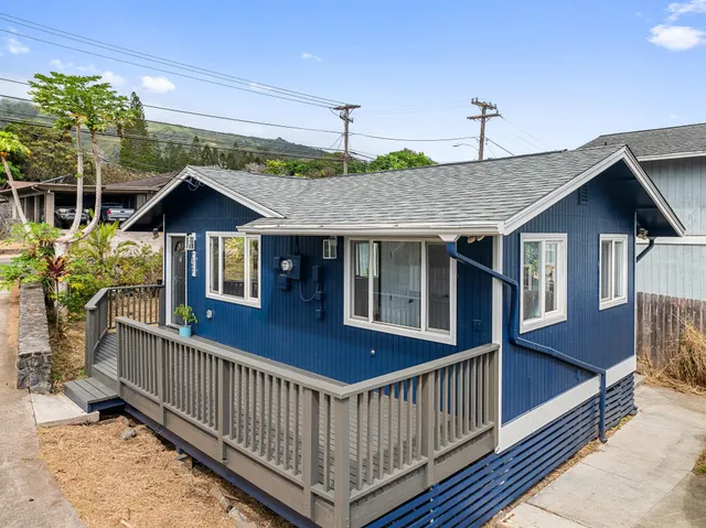 a view of a house with wooden deck and furniture
