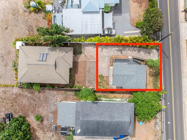 an aerial view of a house with a yard and a large tree