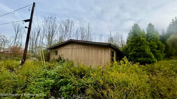a backyard of a house with lots of green space and wooden fence